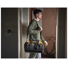 Handwerker trägt eine Stanley FatMax Werkzeugtasche mit Schultergurt auf einer Baustelle. Die Tasche verfügt über mehrere Außentaschen.