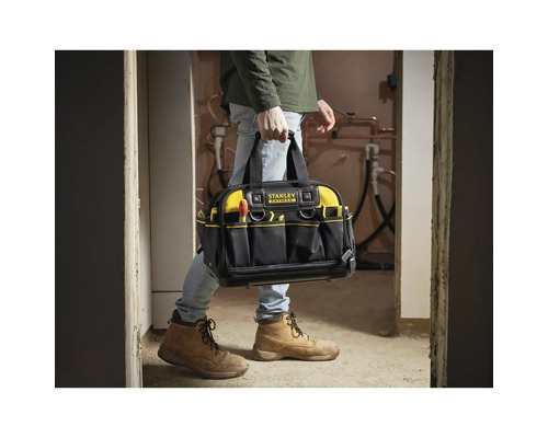 Stanley FatMax Werkzeugtasche aus robustem Textilmaterial mit zahlreichen Außenfächern, getragen von einer Person auf einer Baustelle.