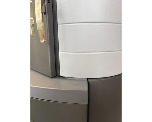 Detailansicht eines Kaminofens mit gebogener Verkleidung und Metallgehäuse.