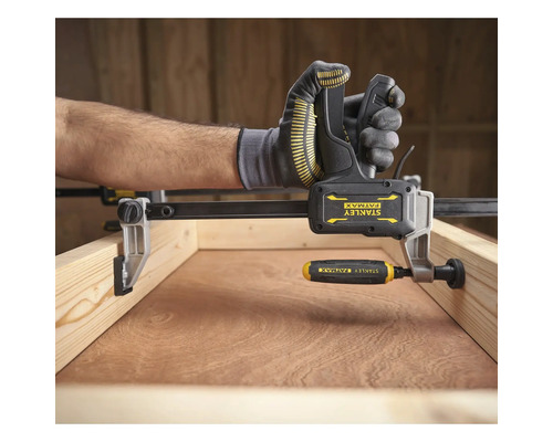 Stanley FatMax Einhandzwinge fixiert einen Holzrahmen.