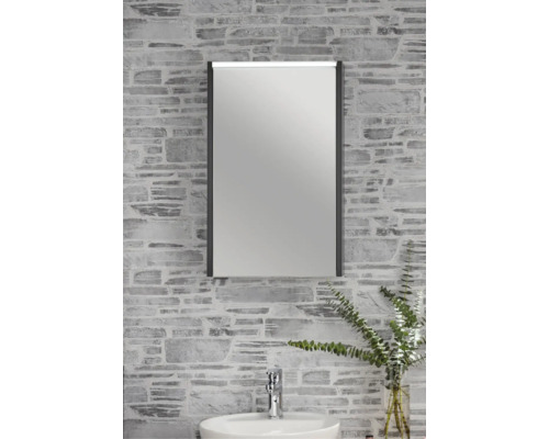 Moderner Badezimmer-Spiegelschrank mit LED-Beleuchtung über einem Waschbecken an einer Wand in Steinoptik.