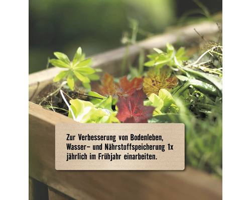 Gartenabfälle zur Bodenverbesserung in einem Holzbeet mit dem Hinweis, diese einmal jährlich im Frühjahr einzuarbeiten.