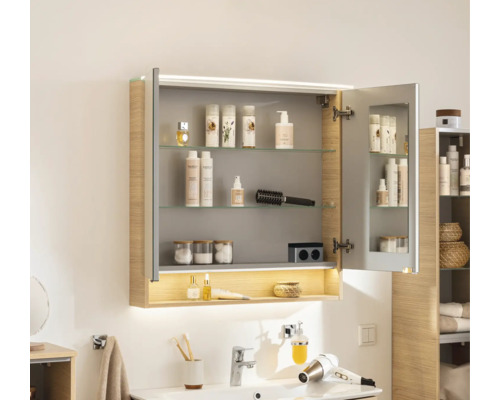 Badezimmer-Spiegelschrank mit LED-Beleuchtung, offenem Ablagefach, Glasböden und Seitenwänden in Holzdekor.