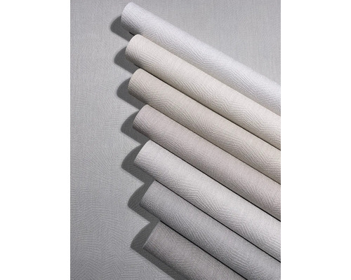 Verschiedene Tapetenrollen in neutralen Tönen mit strukturierter Oberfläche und Zickzack-Muster.