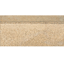 Mauerstein aus Beton mit strukturierter und offenporiger Oberfläche.