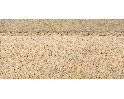 Mauerstein aus Beton mit strukturierter und offenporiger Oberfläche.
