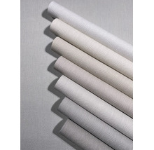 Verschiedene Tapetenrollen in neutralen Tönen mit strukturierter Oberfläche und Zickzack-Muster.
