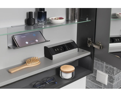 Innenansicht Badezimmer-Spiegelschrank mit integrierter Steckdose, USB-Anschlüssen, Glasablage und Smartphone-Halterung.