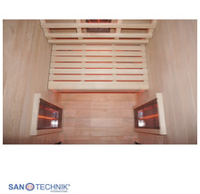 Innenansicht einer Infrarotkabine mit Holzbänken und drei Infrarotstrahlern. Sanotechnik International Logo.