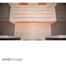 Innenansicht einer Infrarotkabine mit Sitzbank aus hellen Holzlatten und warmer Beleuchtung. Sanotechnik International Logo.