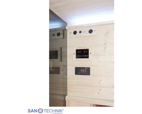 Digitale Steuerung einer Infrarotkabine von Sanotechnik mit Temperaturanzeige und Radiobedienfeld an einer Holzwand.