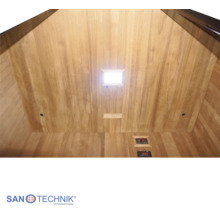 Innenansicht einer Infrarotkabine mit heller Holzverkleidung, integrierter Deckenleuchte und digitalem Bedienfeld. Sanotechnik International Logo.