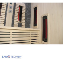 Innenansicht einer hellen Infrarotkabine mit Holzverkleidung, Steinoptik-Wand, Infrarotstrahlern und Sanotechnik International Logo.