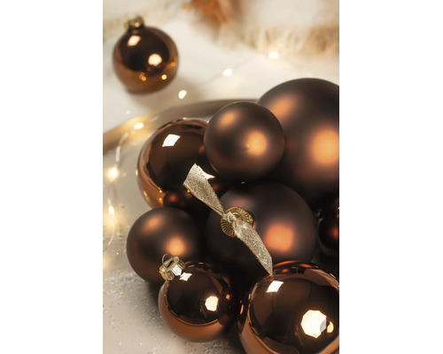 Bronzefarbene Weihnachtskugeln in matter und glänzender Ausführung, arrangiert mit dekorativer Lichterkette.