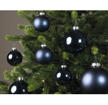Blaue Weihnachtskugeln in verschiedenen Größen, teils matt und teils glänzend, an einem grünen Christbaum.