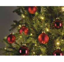 Weihnachtsbaum dekoriert mit matten und glänzenden roten Weihnachtskugeln und warmweißen LED-Lichterketten.