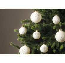 Weiße Weihnachtskugeln mit goldenem Sternmuster an den Zweigen eines grünen Weihnachtsbaums.