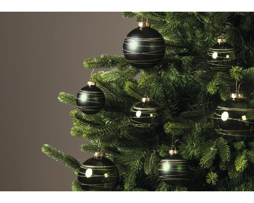 Dunkelgrüne Christbaumkugeln mit goldenen Glitzerstreifen an einem Weihnachtsbaum.