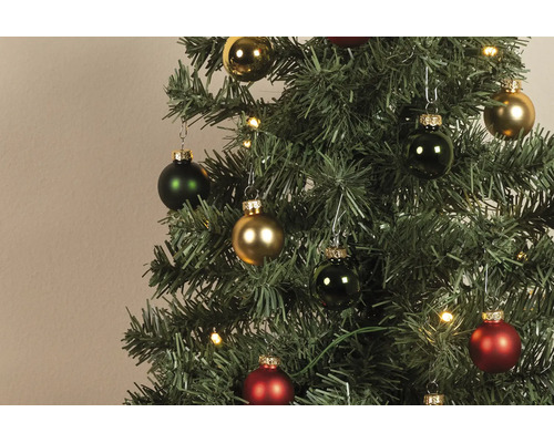 Künstlicher Christbaum mit roten, grünen und goldenen Christbaumkugeln in glänzend und matt sowie warmweißen LED-Lichtern.