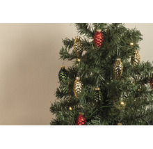 Farbige Glasanhänger in Zapfenform an einem künstlichen Christbaum mit warmweißen Lichtern.