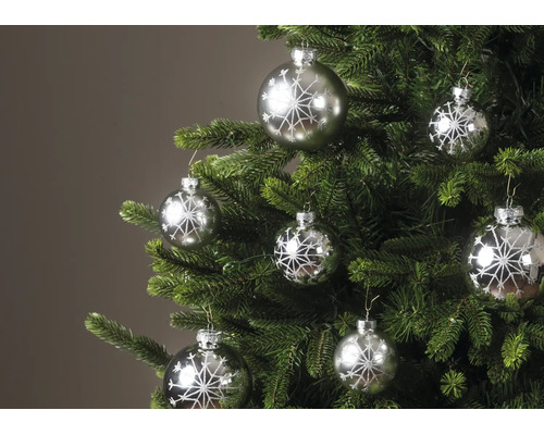 Weihnachtsbaum geschmückt mit silbernen Christbaumkugeln mit glitzerndem Schneeflocken-Motiv.