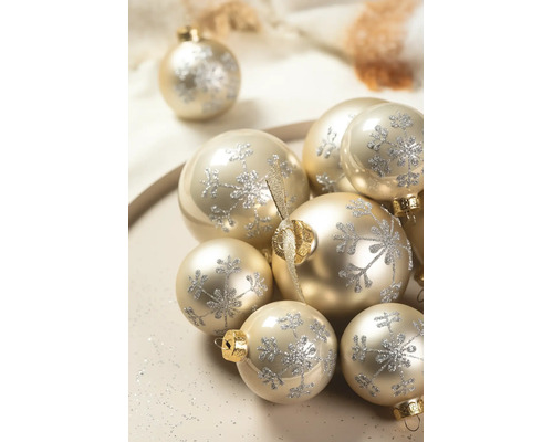 Weihnachtskugeln in Champagner mit silbernen Glitzer-Schneeflocken in verschiedenen Größen und Oberflächen.