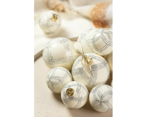 Weiße Weihnachtskugeln mit silbernen Glitzermustern und goldenen Aufhängern in verschiedenen Größen.