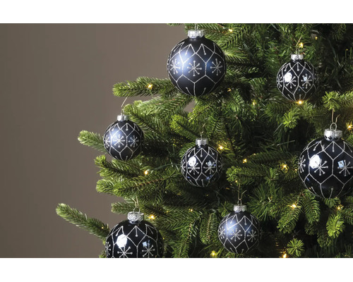 Dunkle Christbaumkugeln mit silbernem Glitzermuster an einem grünen Weihnachtsbaum mit warmweißen Lichtern.