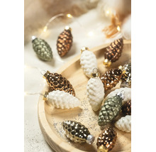 Weihnachtsbaumschmuck in Zapfenform auf einem Holzteller mit Glitzer und festlicher Beleuchtung.