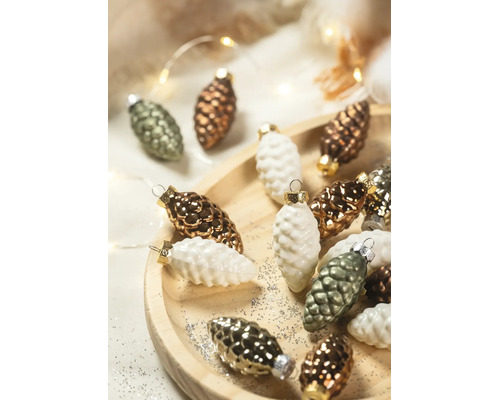 Weihnachtsbaumschmuck in Zapfenform auf einem Holzteller mit Glitzer und festlicher Beleuchtung.