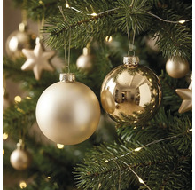 Matte und glänzende Christbaumkugeln an einem geschmückten Christbaum mit Lichterkette und Sternen.