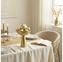 Festlich gedeckter Esstisch mit goldener Schale, Weihnachtskugeln, Kerzenständern, weißem Geschirr mit Goldrand und goldenem Besteck.