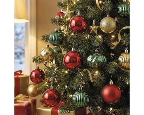 Festlich geschmückter Weihnachtsbaum mit gerippten, facettierten und glitzernden Kugeln, Sternen und Lichtern. Geschenke liegen unter dem Baum.