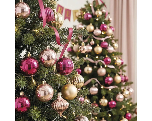 Zwei festlich geschmückte Christbäume mit rosa und goldenen Weihnachtskugeln, Bändern und warmen Lichterketten.