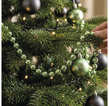 Perlenkette für den Weihnachtsbaum, dekoriert an einem Tannenbaum mit Christbaumkugeln und Lichterkette.