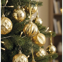 Weihnachtsbaum geschmückt mit verschiedenen goldenen Ornamenten und warmweißen Lichterketten.