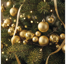Festlicher Weihnachtsbaum geschmückt mit verschiedenen goldenen Christbaumkugeln, einem glänzenden Schleifenband und einer hellen Lichterkette.