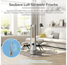 Schlanker, silberner Luftreiniger in einem hellen, modernen Wohnzimmer mit weißem Sofa. Inklusive H13 HEPA-Filter für saubere, frische Luft.