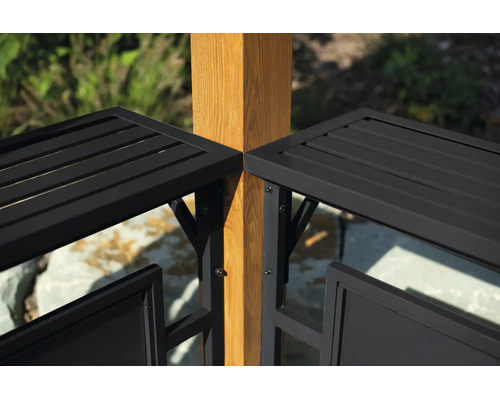 Detailansicht eines schwarzen Metallzauns mit horizontalen Lamellen, montiert an einem quadratischen Holzpfosten im Garten.
