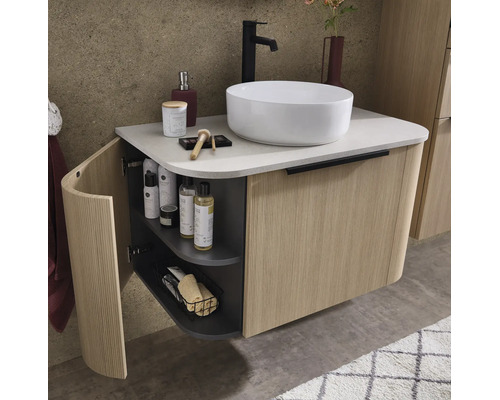 Wandhängender Waschtischunterschrank mit geriffelter Holzfront, weißem Aufsatzwaschbecken und schwarzer Armatur in einem modernen Badezimmer.