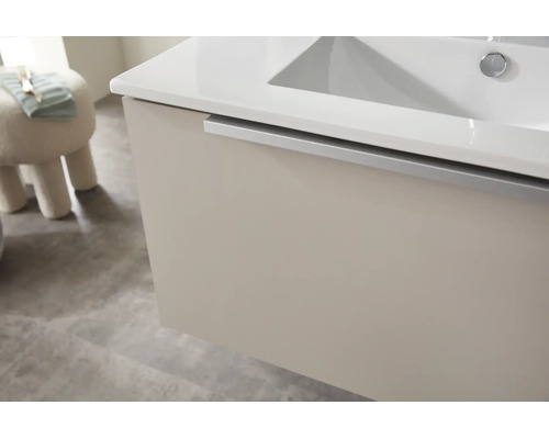 Waschtischunterschrank mit weißem Waschbecken und silberner Griffleiste in einem modernen Badezimmer.