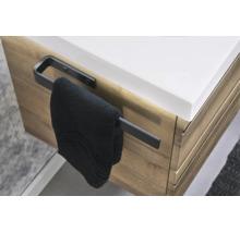 Schwarzer Handtuchhalter seitlich an einem Waschtischunterschrank in Holzoptik montiert mit einem Handtuch.