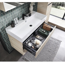 Moderner Bad-Waschtisch mit weißem Keramik-Waschbecken, Holz-Unterschrank und geöffneter Schublade mit organisierten Ablagefächern.