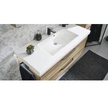 Moderner Badezimmer-Waschtisch mit weißem Waschbecken, Holzunterschrank und schwarzer Armatur vor einer Wand mit Sechseck-Fliesen.