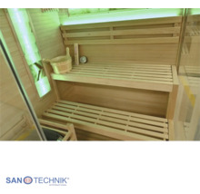 Innenansicht einer modernen Sauna aus Holz mit zweistufigen Liegebänken, Holzeimer, Saunazubehör und stimmungsvoller LED-Beleuchtung.