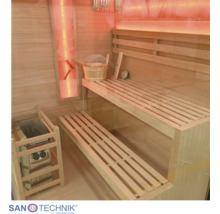 Innenansicht einer Holzsauna mit zweistufiger Saunabank, Saunaofen, Aufgusseimer und integrierter Beleuchtung.