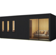 Modernes Gartenhaus aus Holz mit senkrechter Fassadenverkleidung, drei schmalen Fenstern und einer großen Schiebetür mit Blick auf ein Sofa.