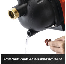 Hand hält Wasserablassschraube an einer Wasserpumpe zum Frostschutz, Wasser fließt aus der Öffnung.
