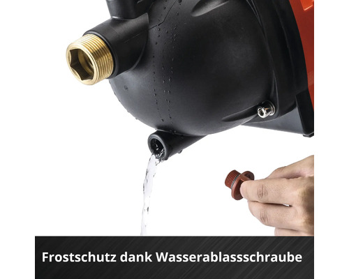 Hand hält Wasserablassschraube an einer Wasserpumpe zum Frostschutz, Wasser fließt aus der Öffnung.