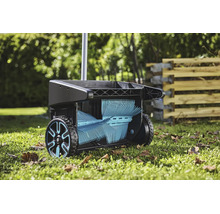 Gardena Laub- und Rasensammler mit rotierenden Bürsten auf einem Rasen im Garten.